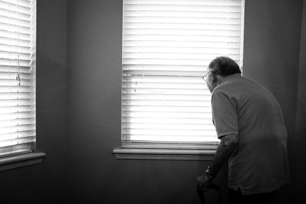photo de personne âgée devant une fenêtre